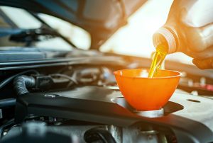 oil being poured in a funnel feeding the car engine | Lanham, MD